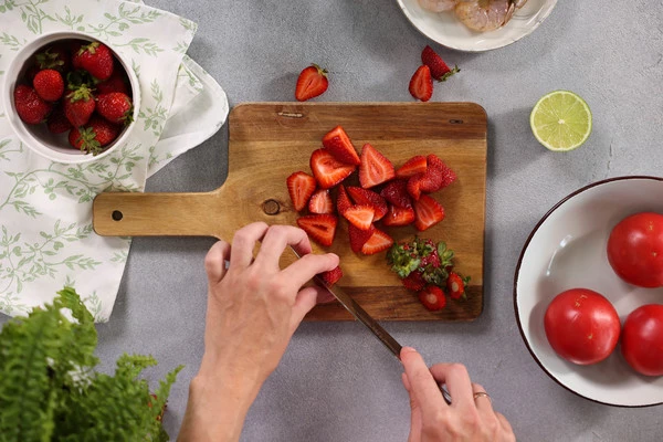 Клубнику вымыть, нарезать пополам.