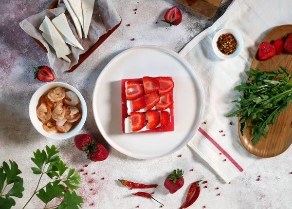 Клубнику вымыть, нарезать ломтиками. Выложить на брынзу.