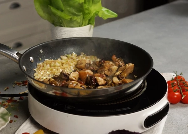 Белые грибы разморозить, промыть, слить лишнюю воду, добавить к луку, жарить 5-6 минут на среднем огне. 