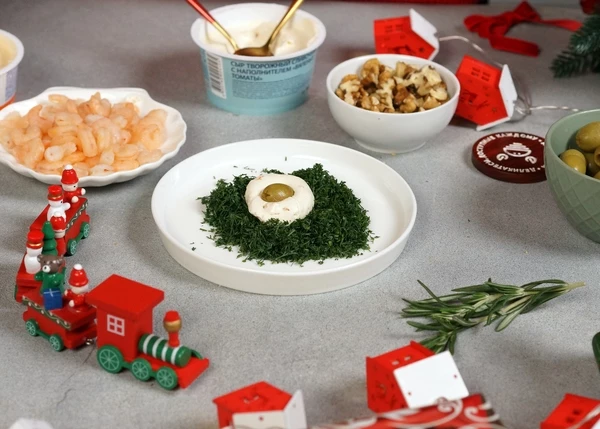 В творожный сыр с томатами завернуть оливки, обвалять в нарезанном укропе. 