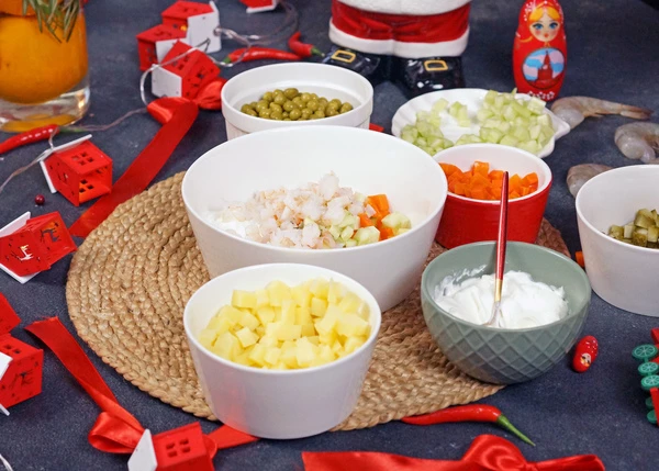 Креветки разморозить и отварить в подсоленной воде в течение 1,5-2 минут, 2-3 штуки оставить, остальные мелко нарезать. Смешать креветки,  картофель, морковь, огурцы, горошек, заправить йогуртом, посолить и поперчить. Хорошо перемешать.