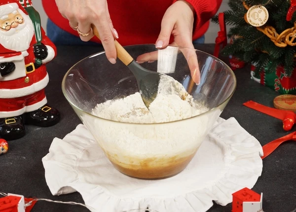 Ввести яйца, перемешать. Добавить муку.