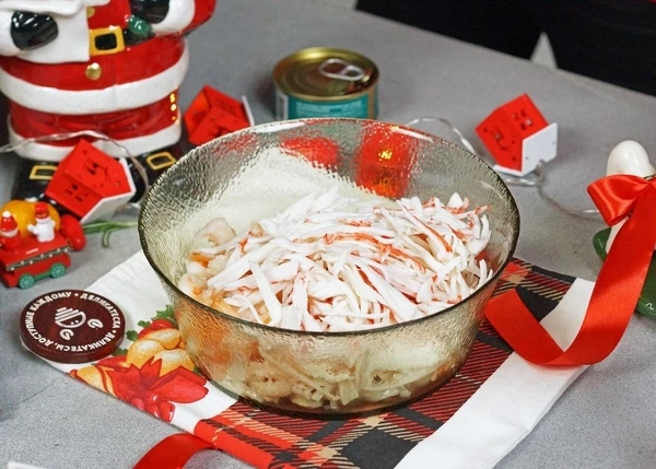 Крабовые палочки разморозить, разобрать на тонкие волокна. Добавить к морепродуктам. 