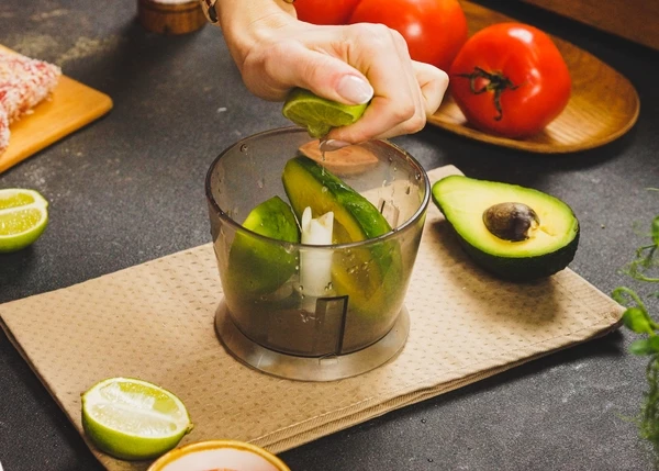 Авокадо вымыть, очистить, переложить в чашу блендера, посолить, добавить соус и сок лайма. Измельчить в пюре. 