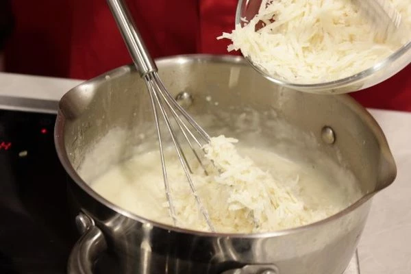 Затем к муке влить подогретое молоко и взбитое яйцо, интенсивно размешивая венчиком, чтобы не было комков.