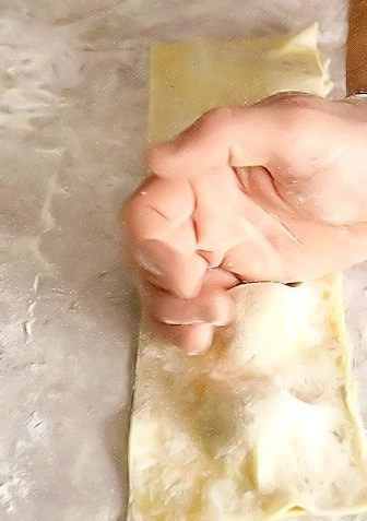 Раскатайте тесто машинкой для пасты или на присыпанной мукой поверхности в 2 тонких пласта. На один пласт выложите по 1 ст. л. начинки на расстоянии 3-3,5 см. Слегка взбейте яйцо и тонкой кисточкой смажьте места будущей склейки. Накройте вторым слоем теста, пальцами или ребром ладони прижмите места, не занятые начинкой.