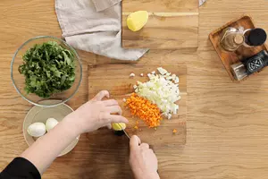 Щавель и шпинат нарезать крупной соломкой, картофель — средним кубиком, морковь и лук — мелким кубиком. Обычно для супа их слегка пассеруют на растительном масле, но у нас диетический суп, поэтому обжаривать мы их не будем.