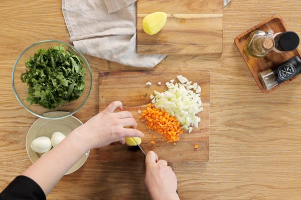 Щавель и шпинат нарезать крупной соломкой, картофель — средним кубиком, морковь и лук — мелким кубиком. Обычно для супа их слегка пассеруют на растительном масле, но у нас диетический суп, поэтому обжаривать мы их не будем.