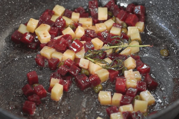 Пармезан нарезать кубиком 0,5 см. Затем выложить его в сковороду к свекле, перемешать и снять с огня. 