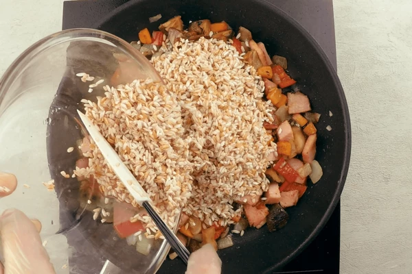 Рис девзира промыть, замочить на 15-20 минут в теплой воде, затем засыпать к овощам и карбонаду.