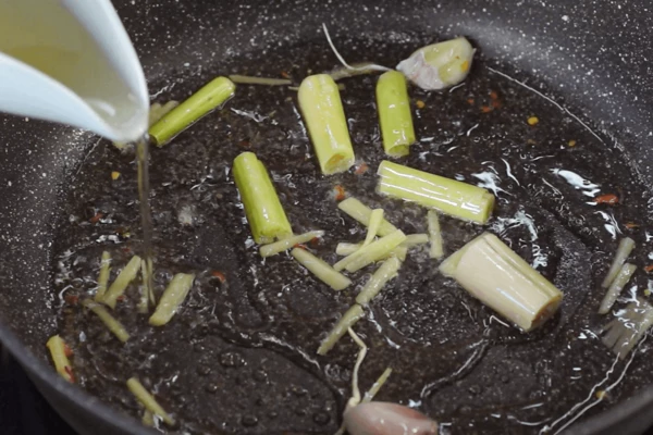 Аккуратно влить белое вино и перемешать, чтобы деглазировать сковороду. Довести до кипения и варить, пока объем не уварится наполовину, примерно 3 – 4 минуты.