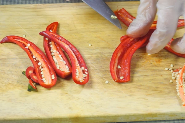 Перец красный острый разрезать пополам, очистить от семян и перегородок.