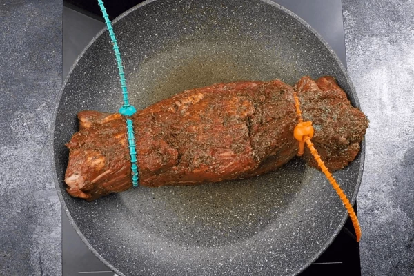 Обжарить на сильно разогретой сковороде со всех сторон примерно по 30-40 секунд, чтобы «запечатать» мясной сок. Можно для удобства стянуть края специальными силиконовыми жгутами.