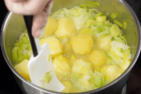 Добавить к луку готовый картофель с отваром, снять с огня.