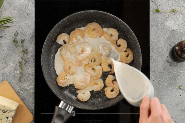  Влить в креветки кокосовое молоко.