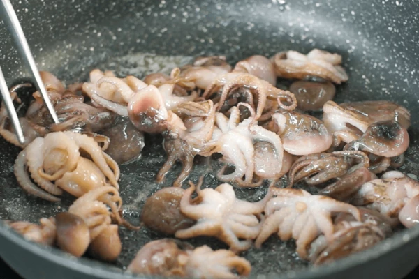 Молодых осьминогов разморозить на нижней полке холодильника. 
В сковороде растопить сливочное масло. Обжарить осьминожек в течение 3 - 4 минут, слегка посолить.
