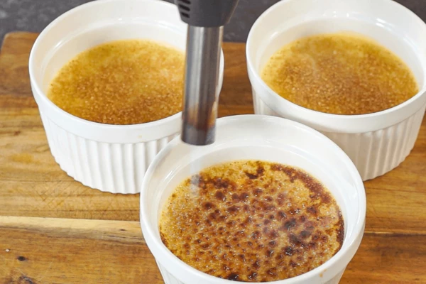 Достать из духовки, дать остыть при комнатной температуре и убрать в холодильник на пару часов. Готовое крем-брюле посыпать сахаром и опалить горелкой.