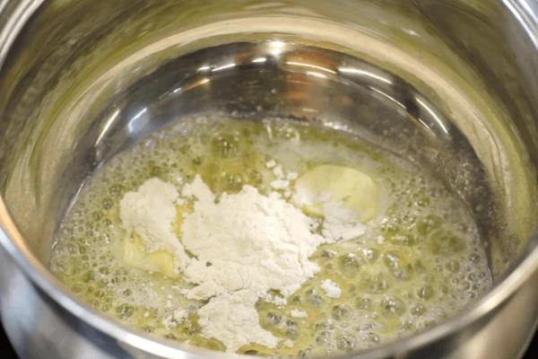 В сотейнике растопить сливочное масло, добавить муку, перемешать венчиком, чтобы не образовались комочки. 

