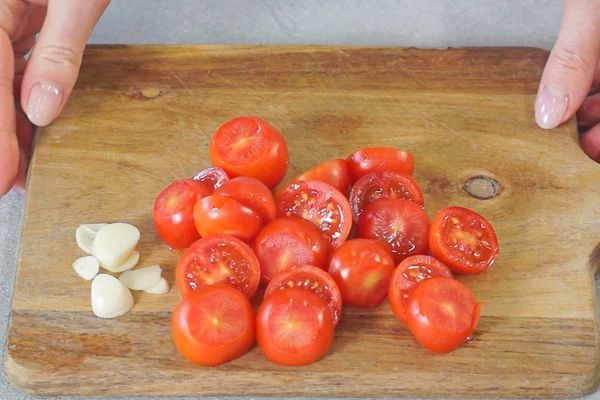 Томаты черри и чеснок нарезать.