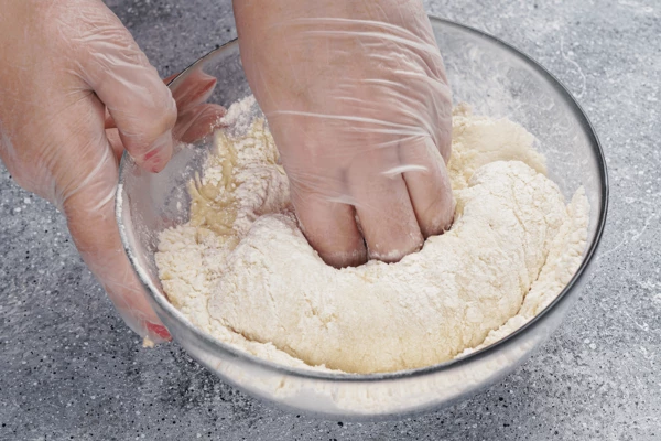 Постепенно всыпать муку и замесить тесто.