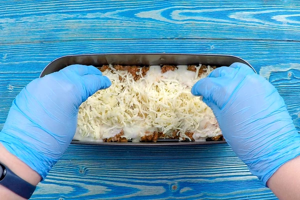 Собрать лазанью:  (идеально готовить 6 слоев, но допускается и 4). На дно выложить один лист лаваша, затем часть мясной начинки, часть соуса бешамель, натертый сыр, снова лист лаваша. 