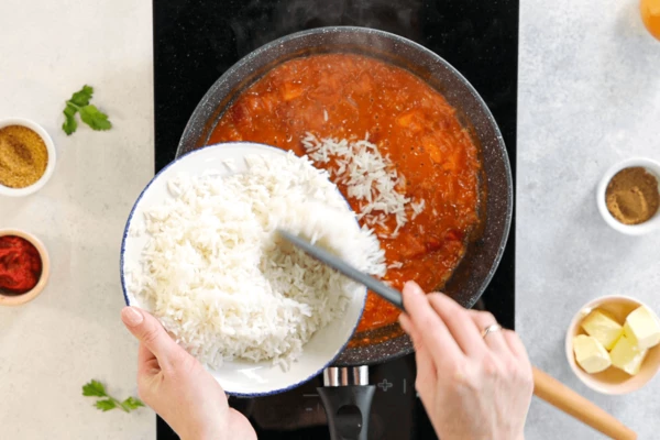 Выложить в томатный соус отварной рис, перемешать, снять с огня.
