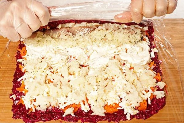 С помощью пленки, свернуть нашу "селедку под шубой" рулетом.