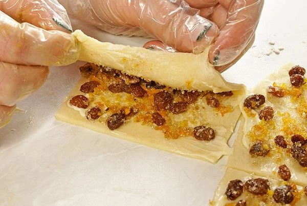 Сложить прямоугольники с начинкой пополам, слегка растягивая пальцами.