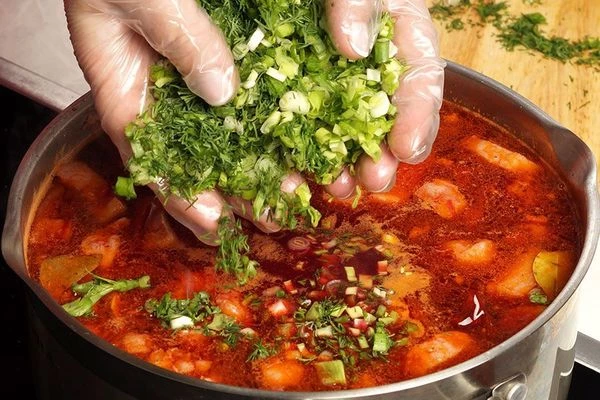 В кипящий суп добавить свекольную заправку, мелко нарезанную зелень. Снять с огня.