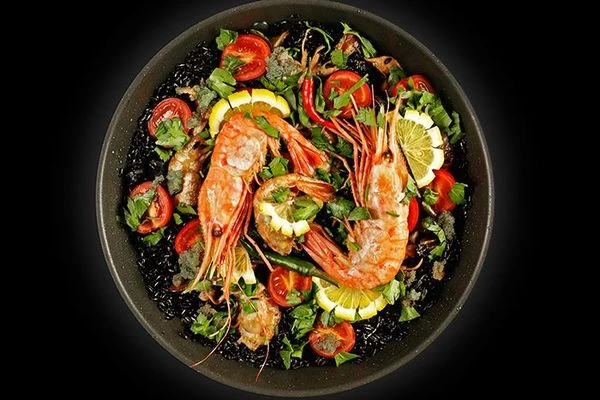 Готовую паэлью  оформить рубленной зеленью, готовыми креветками Ботан и дольками лимона.