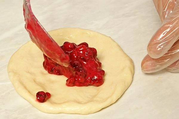 Раскатать шарики скалкой или распределить тесто в виде лепешки руками, выложить начинку в центр ( не кладите много начинки, иначе она вытечет).