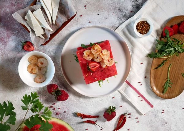 Накрыть вторым ломтиком арбуза, посыпать перцем чили. Оформить креветками и клубникой. Приятного аппетита! 
