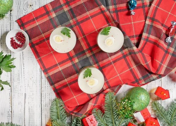 Яйца отварить, почистить, нарезать пополам. 
Выложить половинки яиц на слой с майонезом. Оформить петрушкой и розовым перцем. Залить слоем прозрачного бульона с желатином. Убрать в холодильник до застывания. 

