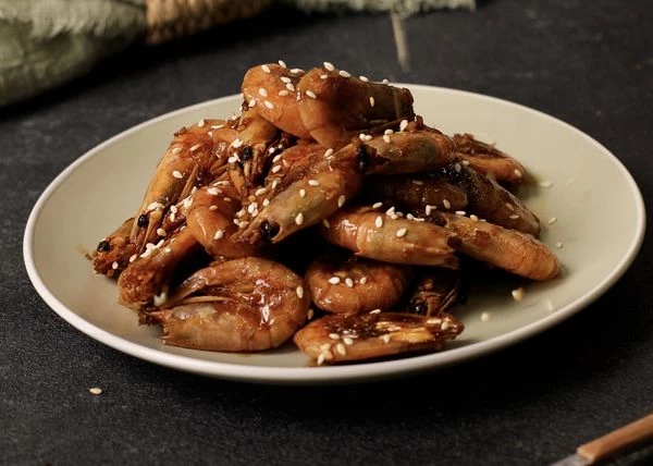 Выложить жареные креветки на тарелку, посыпать кунжутом и подавать к столу горячими. Приятного аппетита!

