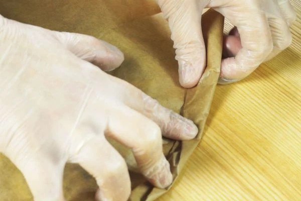 Завернуть края пергамента по кругу, чтобы не развернулись при жарке.