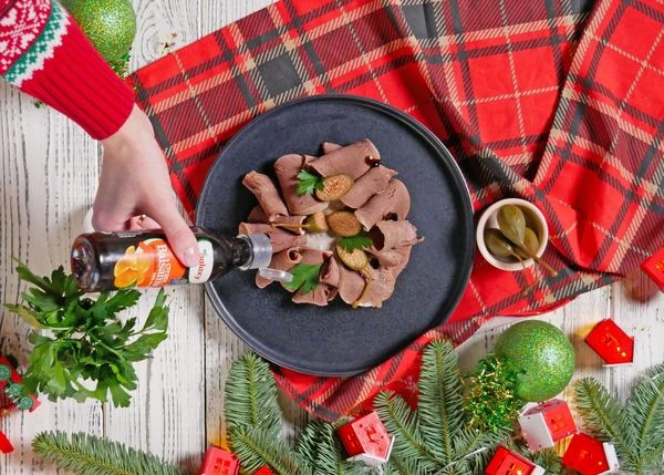 Сверху выложить слайсы отварного говяжьего языка. Оформить крупными каперсами и бальзамическим соусом. Приятного аппетита!
