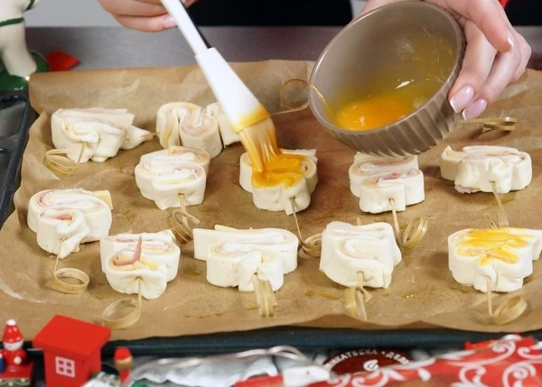 Выложить на пергамент. Смазать желтком. Выпекать в разогретой до 180 градусов 12-15 минут.