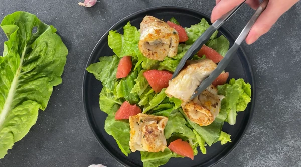 Рядом выложить обжаренные рулетики из хека. 