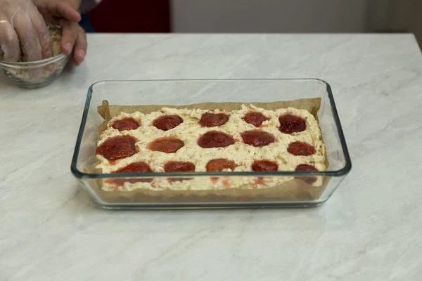 По всему периметру разложите ягоды и слегка вдавите их в тесто.