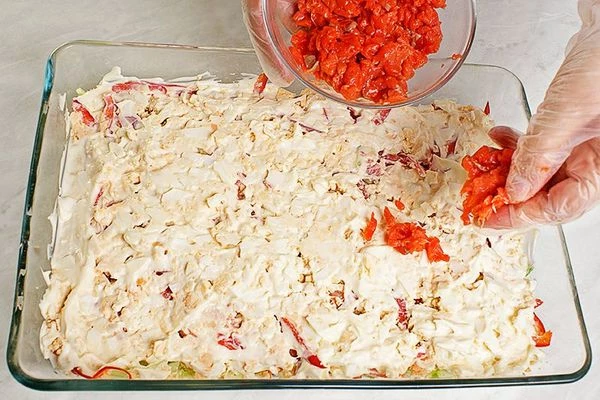  Смазать майонезом. Потом распределить по всей поверхности слой мелко нарезанной слабосоленой рыбы.