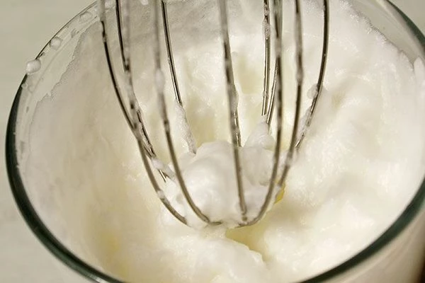 В отдельной чашке взбить венчиком белки с щепоткой соли до образования устойчивых "пиков".