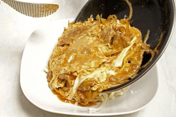 Лапшу ( можно использовать для приготовления гречневую, пшеничную, яичную, рисовую - на ваш вкус) отварить в соответствии с инструкцией на упаковке. Слить воду. Выложить в центр тарелки горкой. Сверху аккуратно одним слоем выложить тушеную говядину с яйцом и соусом.