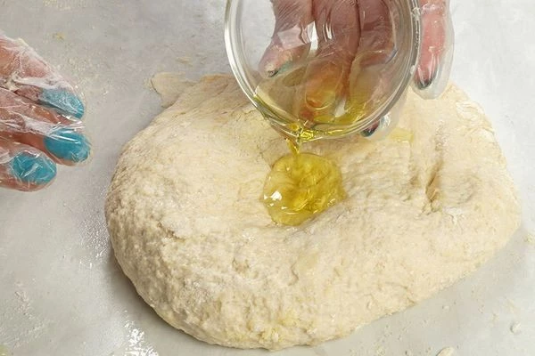 Замесите тесто, в конце влейте оливковое масло (1 ст. л.) и еще раз перемешайте.