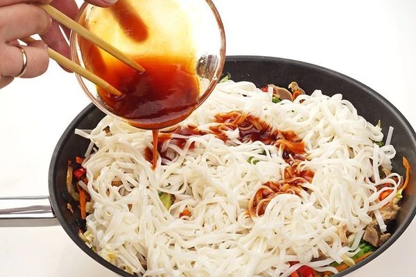 В конце добавить лапшу и смесь кисло-сладкого с соевым соусом. Для тех, кто любит остренькое, можно добавить 1/2 - 1ч.л соуса шрирача или пасты табаджан. Посолить, поперчить по вкусу. Аккуратно перемешать, прогреть лапшу и снять с огня.