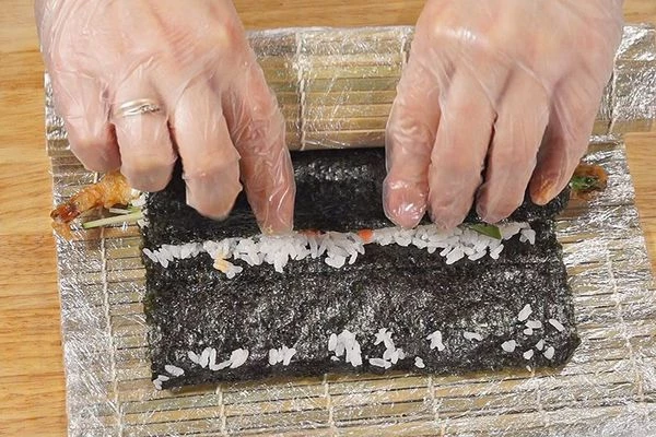  С помощью циновки завернуть ролл.