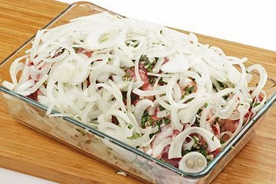 На дно глубокой формы выложить лук, слегка помяв его руками, затем лопатку, сверху уложить еще слой лука. Накрыть пищевой пленкой и уберать на ночь мариноваться в холодильник.