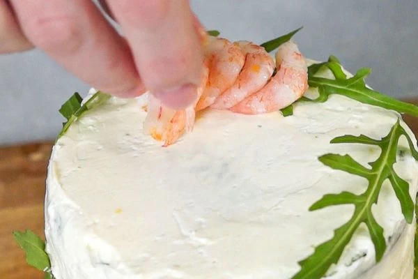 Готовый торт выложить на тарелку для подачи. Оформить креветками и рукколой.
