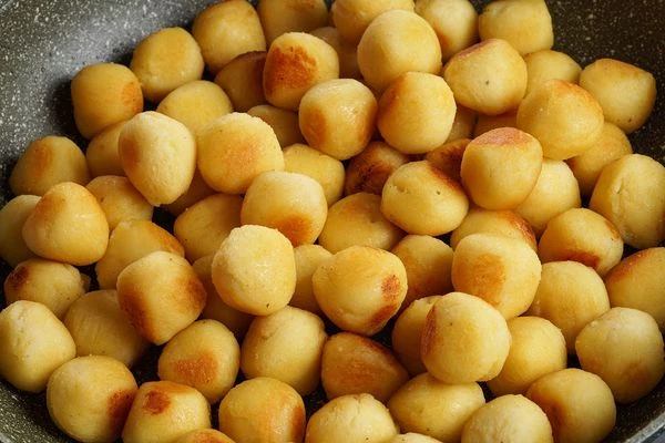 Прогреть картофельные шарики на разогретой с растительным маслом сковороде до румяной корочки.