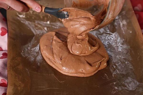 Противень застелить пергаментом. Пергамент смазать сливочным маслом. Тесто распределить по пергаменту. 