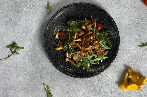 Затем переложить на тарелку для подачи. Сверху выложить обжаренные лисички. 